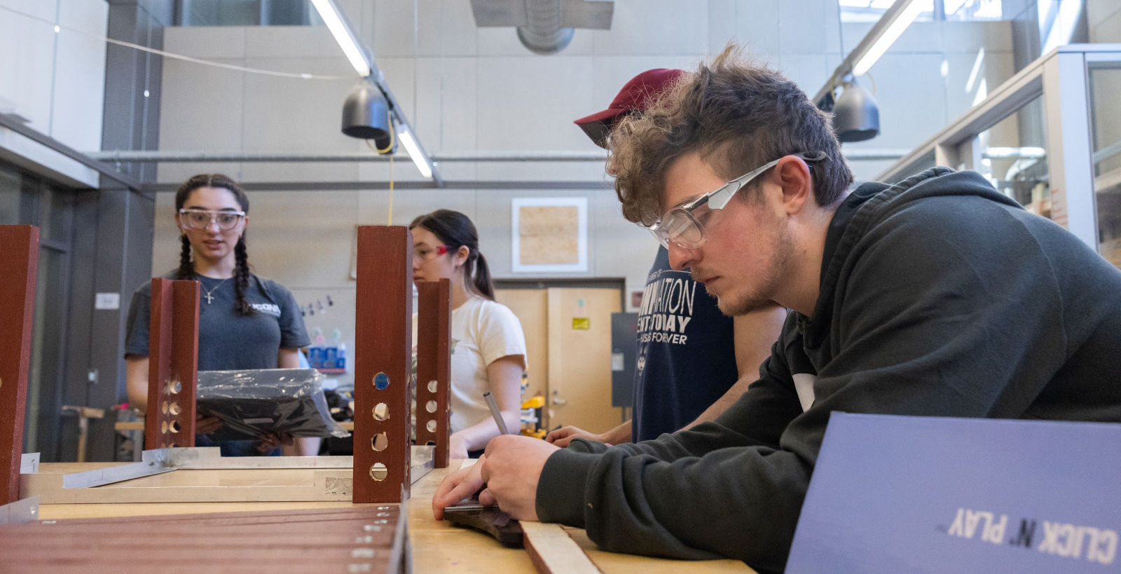 UConn mechanical engineering students, from left, Leila Awad, Kaley Luk, Eddy Ramos and Patrick Miconi work on the prototype of their project for Senior Design Demonstration Day